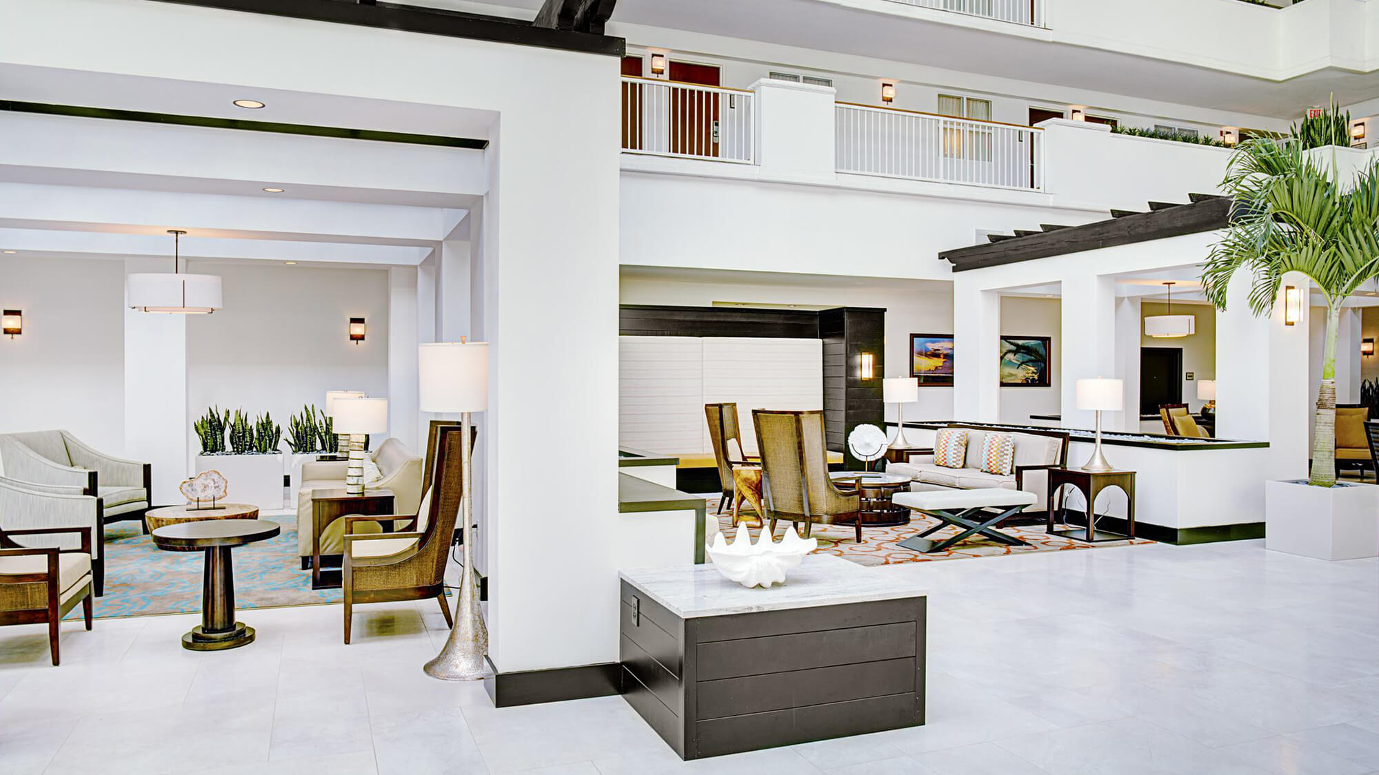 Open indoor lobby with white walls and balconies and lounge seating areas in Destin, FL